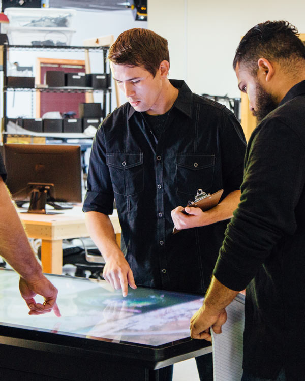 Ideum employees testing interactive applications on an Ideum-made multitouch Platform table.